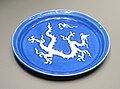 Yuan dynasty Jingdezhen dish with a white dragon and pearl design on a monochrome blue background